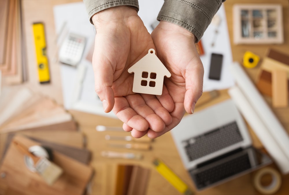 HOA Dispute Lawyer Fort Lauderdale, FL - house plans hands cupped holding wooden house cut out